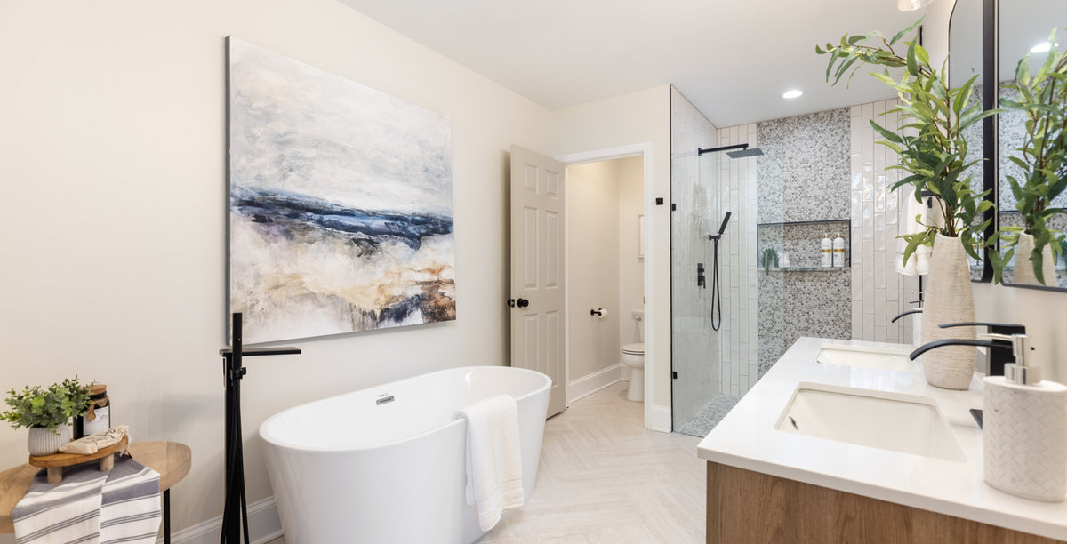 renovated bathroom with herringbone tile, soaking tub, and tiled shower