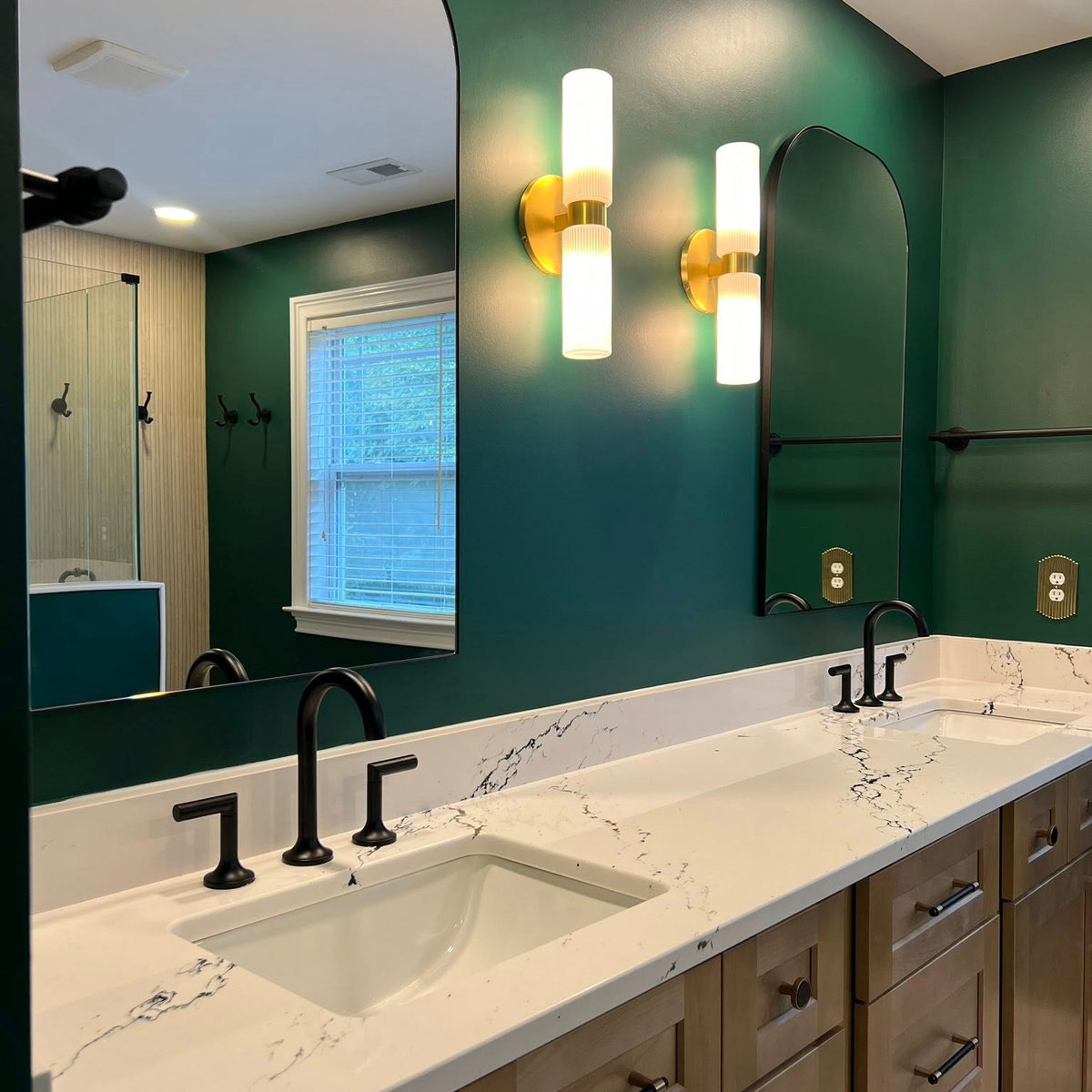 dark green bathroom with stone counters and wooden vanity