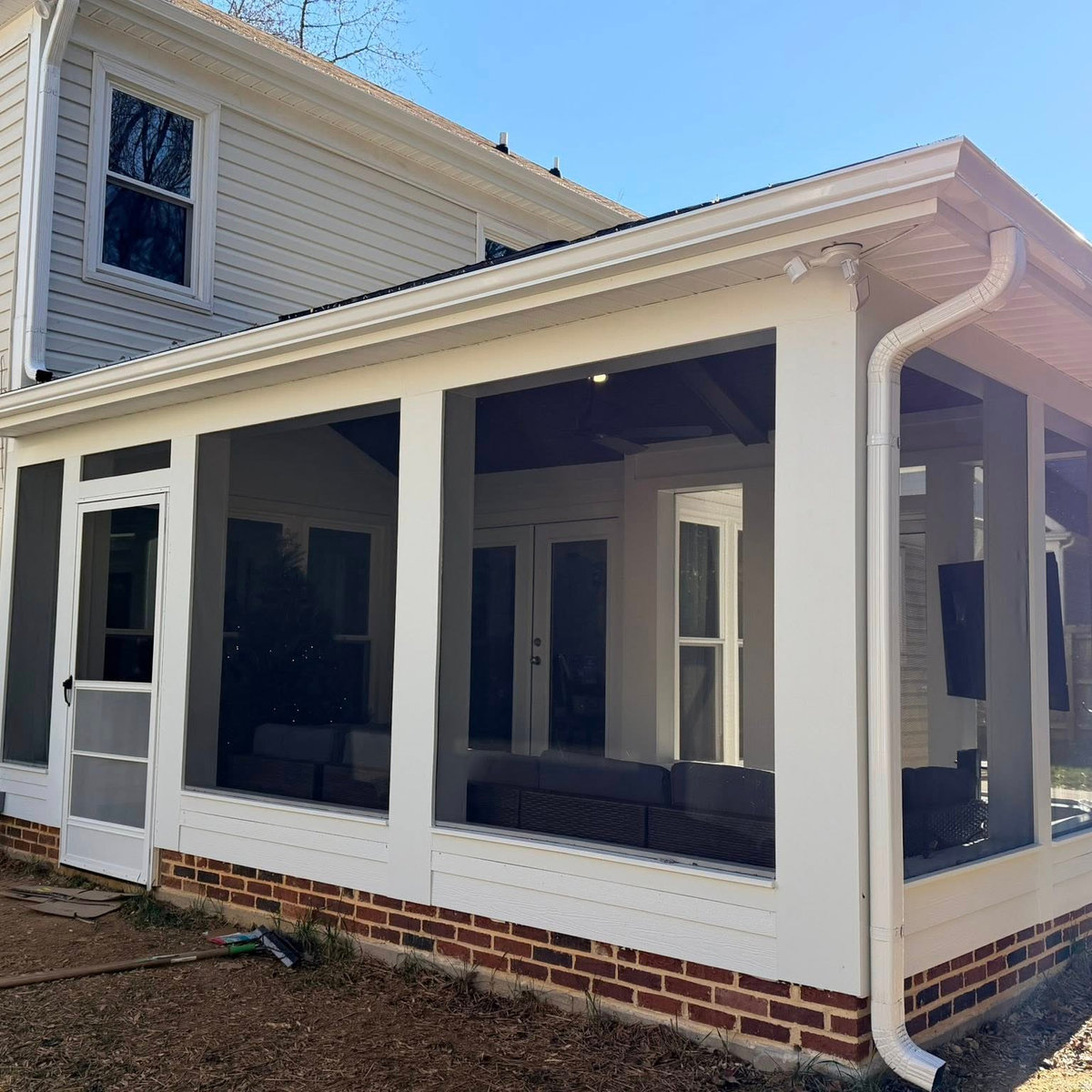 side angle of an all season porch with white trim and gutters