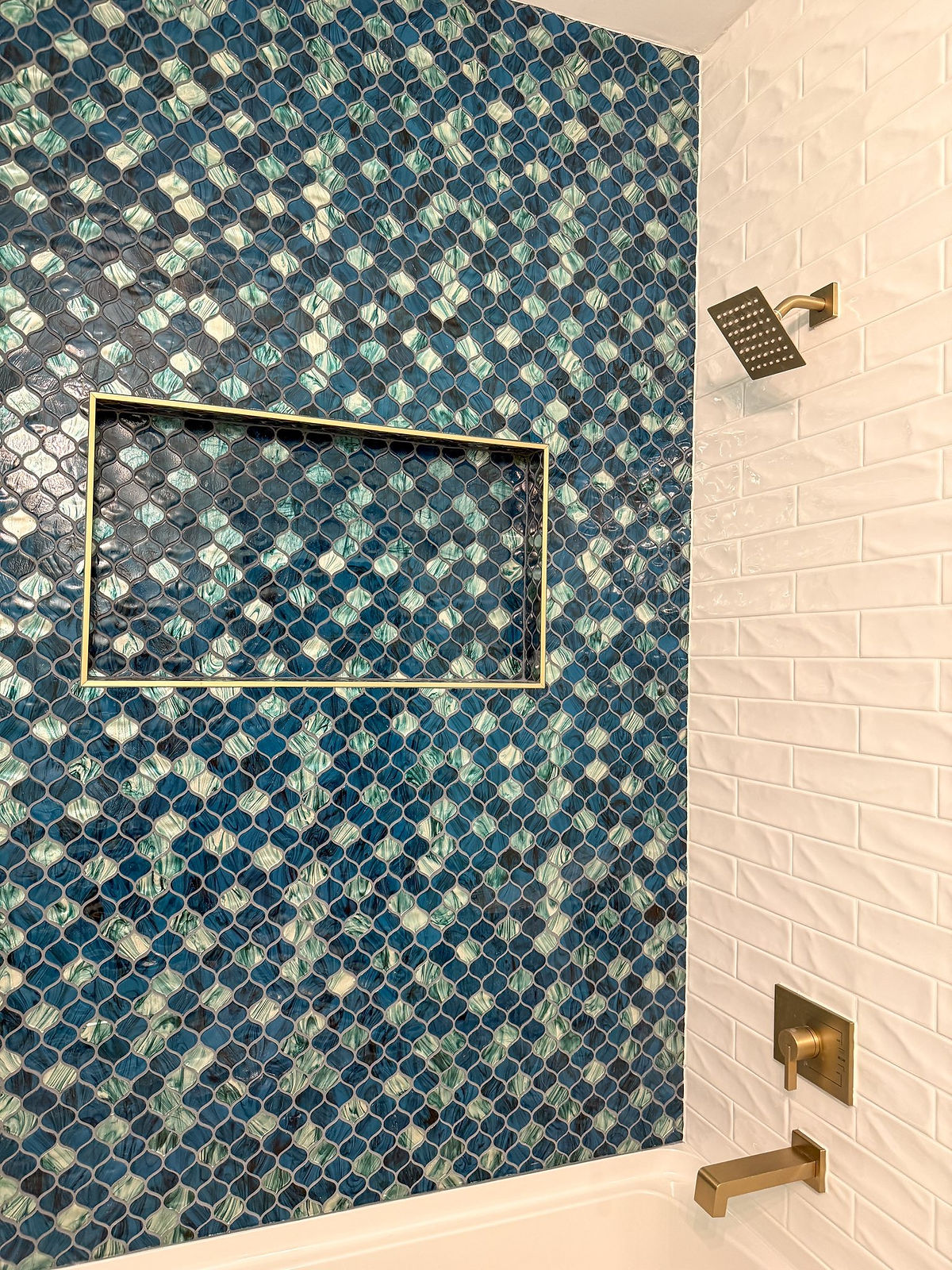 home renovation near Huntersville, NC features a garage that was converted into a bathroom with multicolored blue teardrop shaped tile and square rainshower shower head.