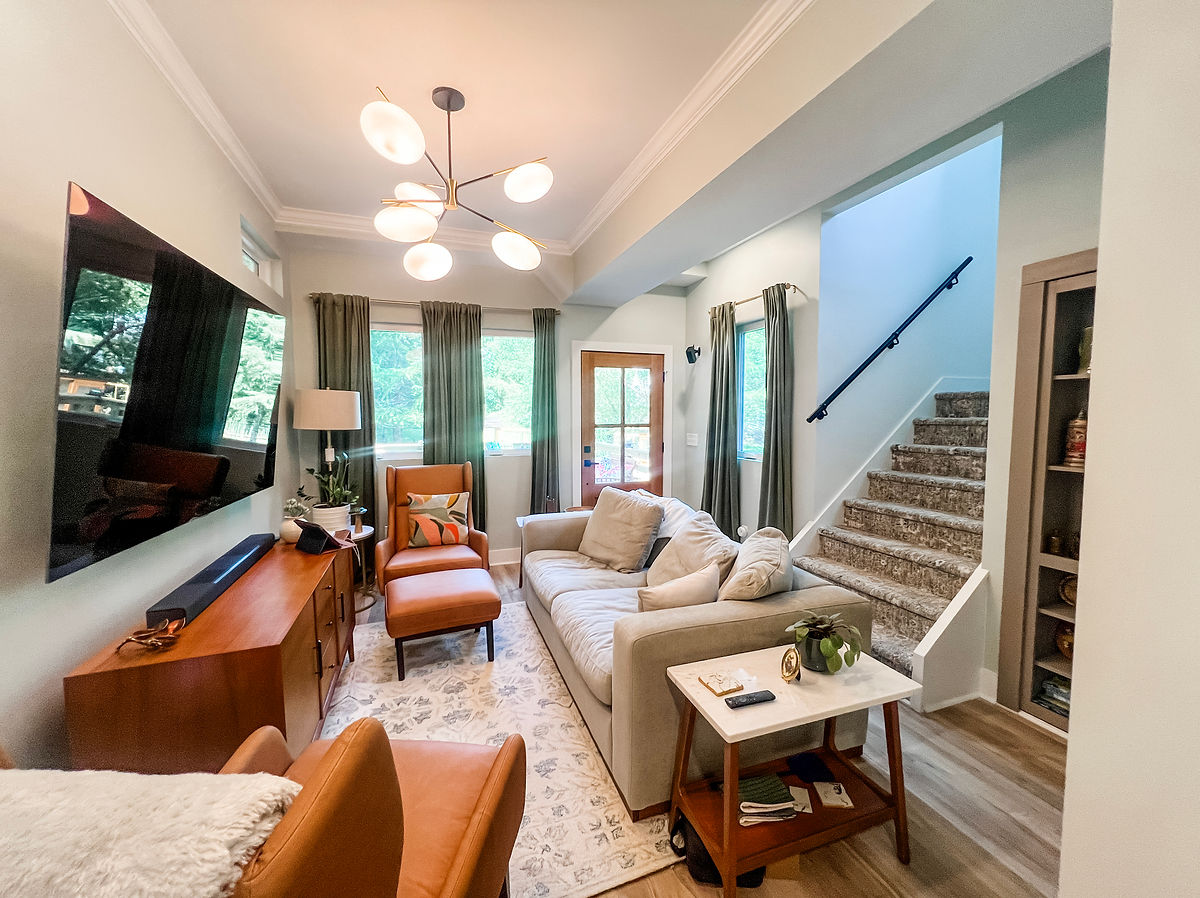 renovated living room with fresh paint, a unique light fixture, and comfortable furniture