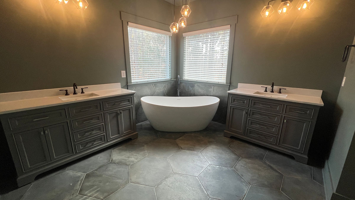 home renovation near Cornelius, NC featuring a renovated bathroom with moody charcoal and slate tiles, and dark gray paint and vanities.