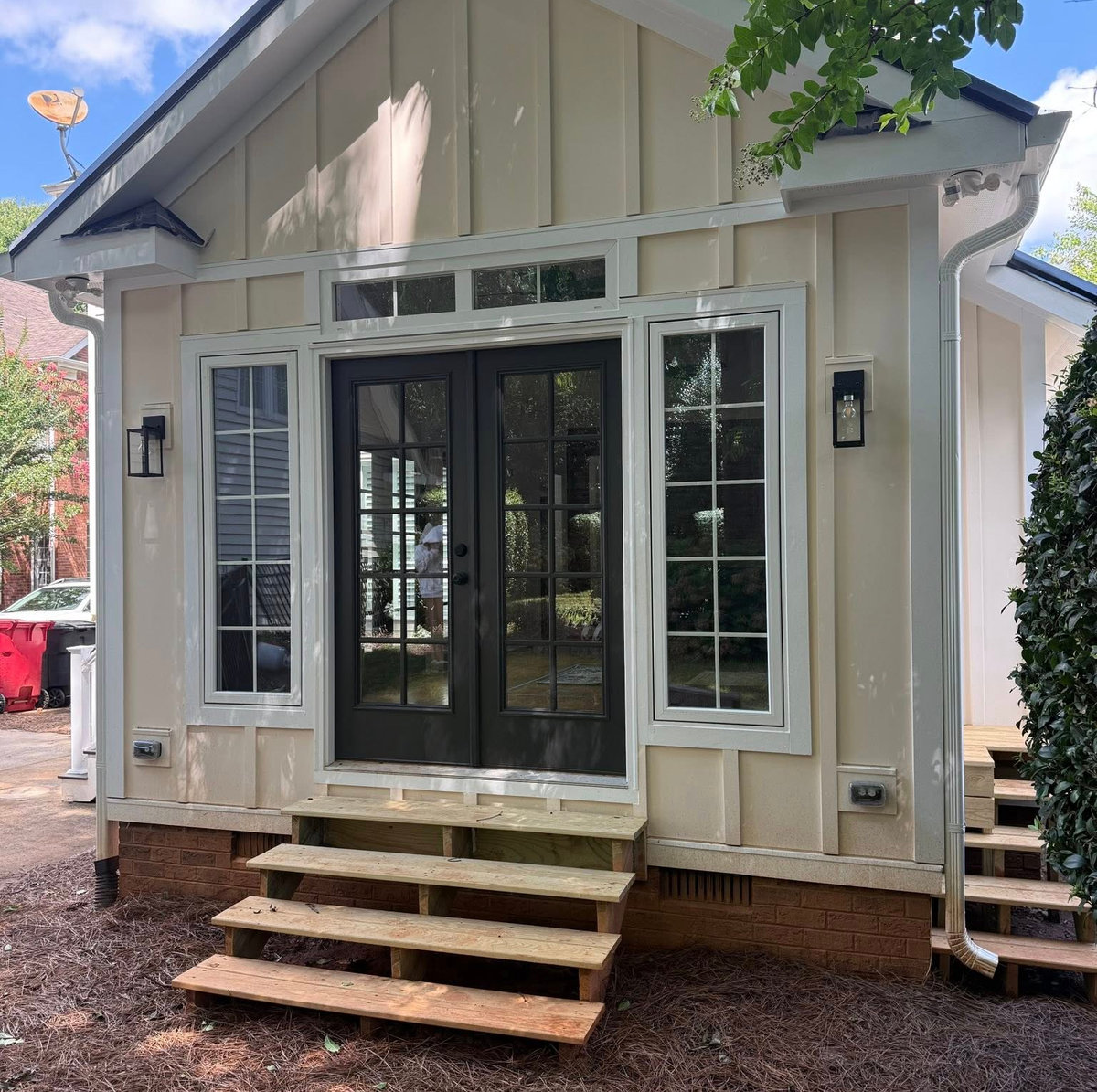 front view of an addition with light yellow board and batten siding