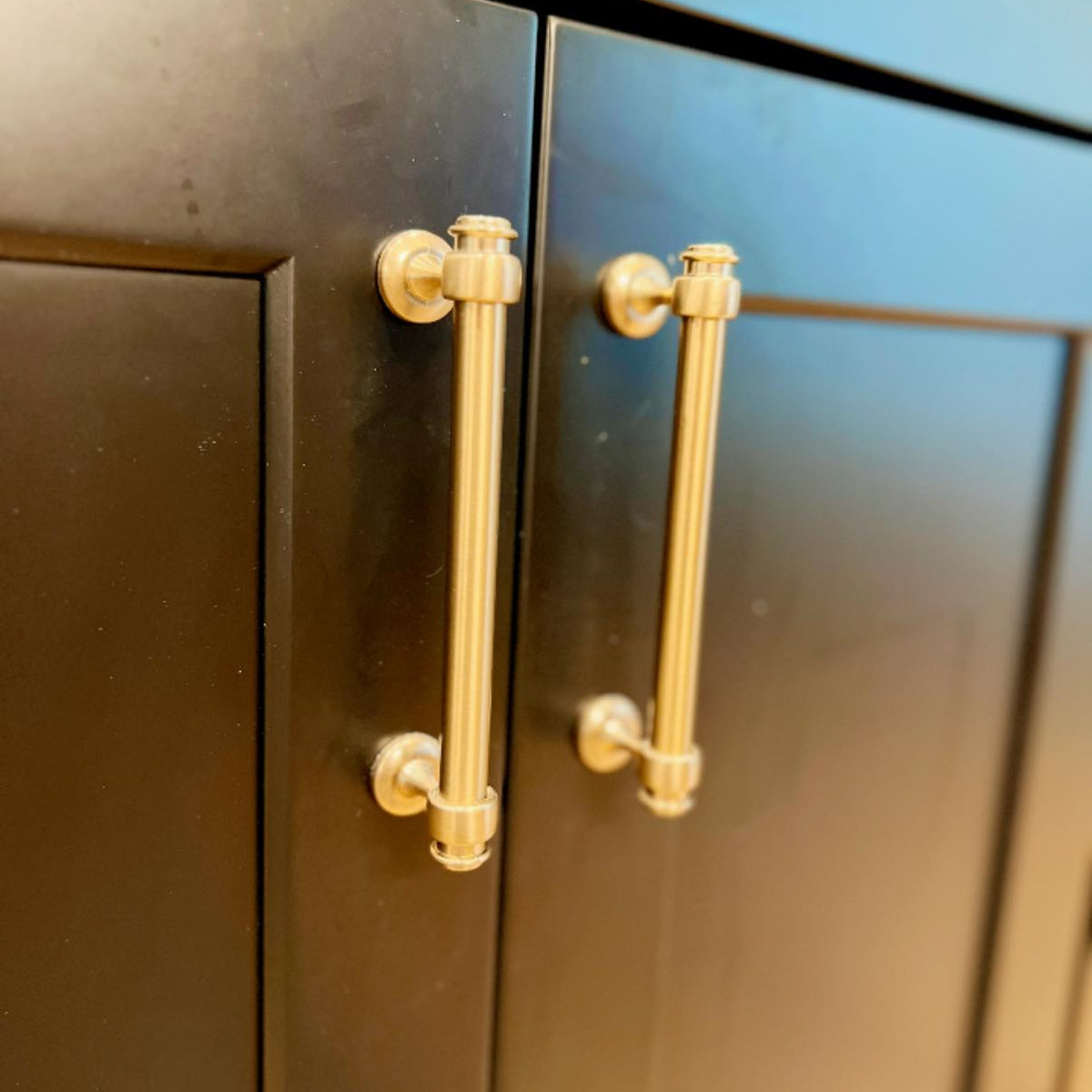 close up on black cabinetry with gold pull handles