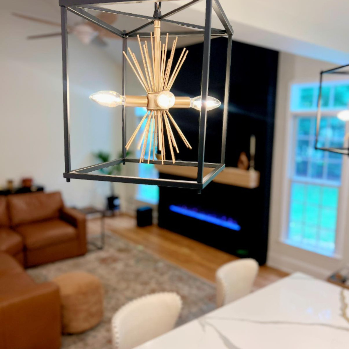 close up on unique modern farmhouse pendant light above large kitchen island looking into open living room