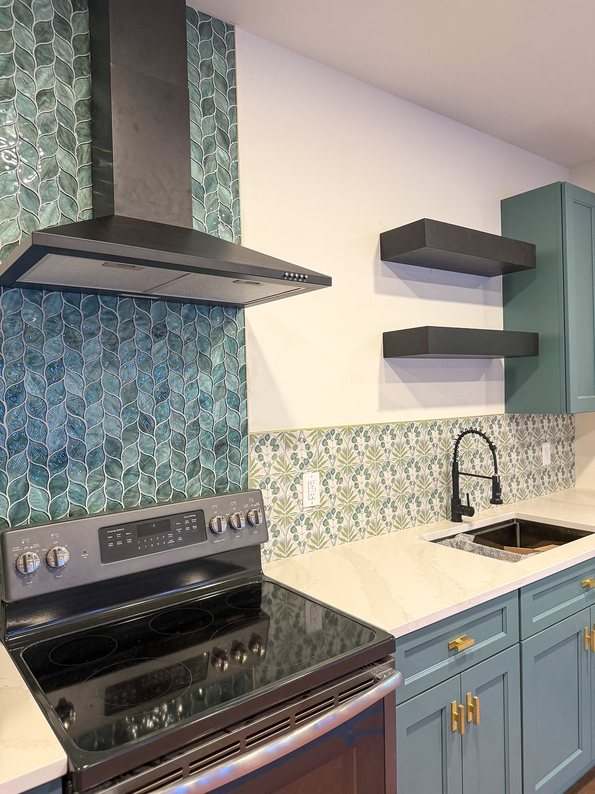 home renovation near Huntersville, NC featuring garage conversion to art studio with blue/teal cabinetry and glass tile backsplash.