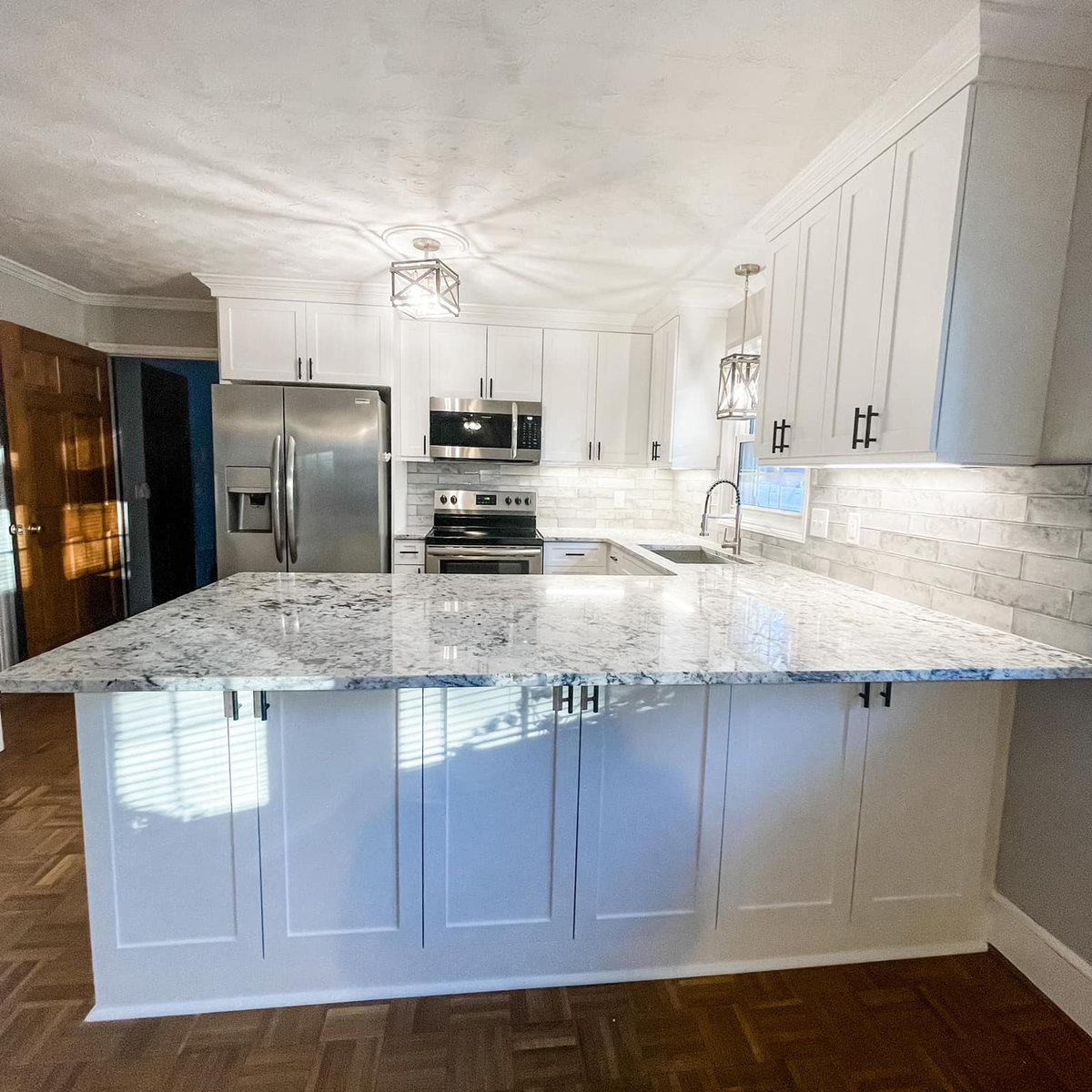 small space renovation of a kitchen with white cabinetry, granite countertops, and stainless steel appliances