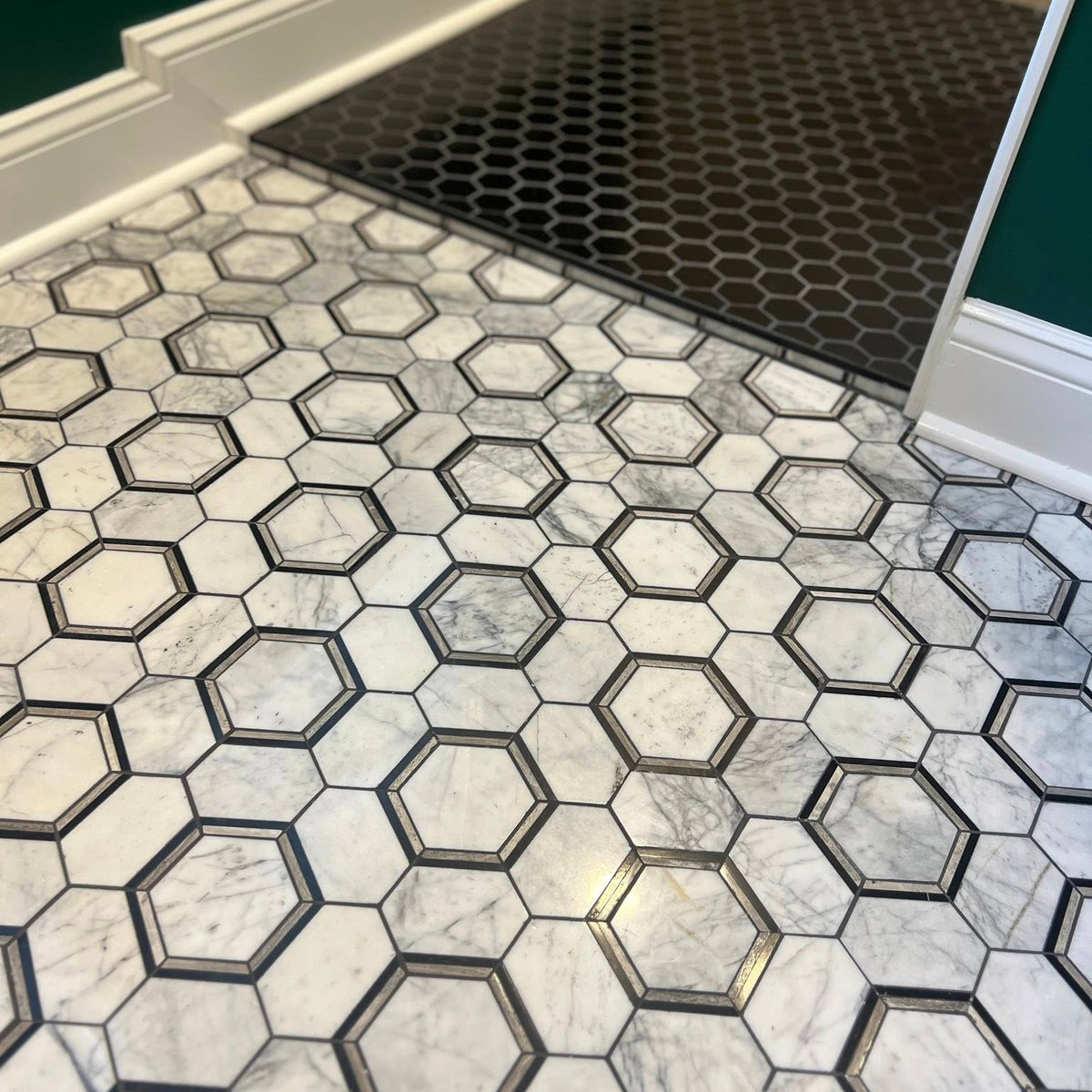 marble hex flooring with black details on some tiles