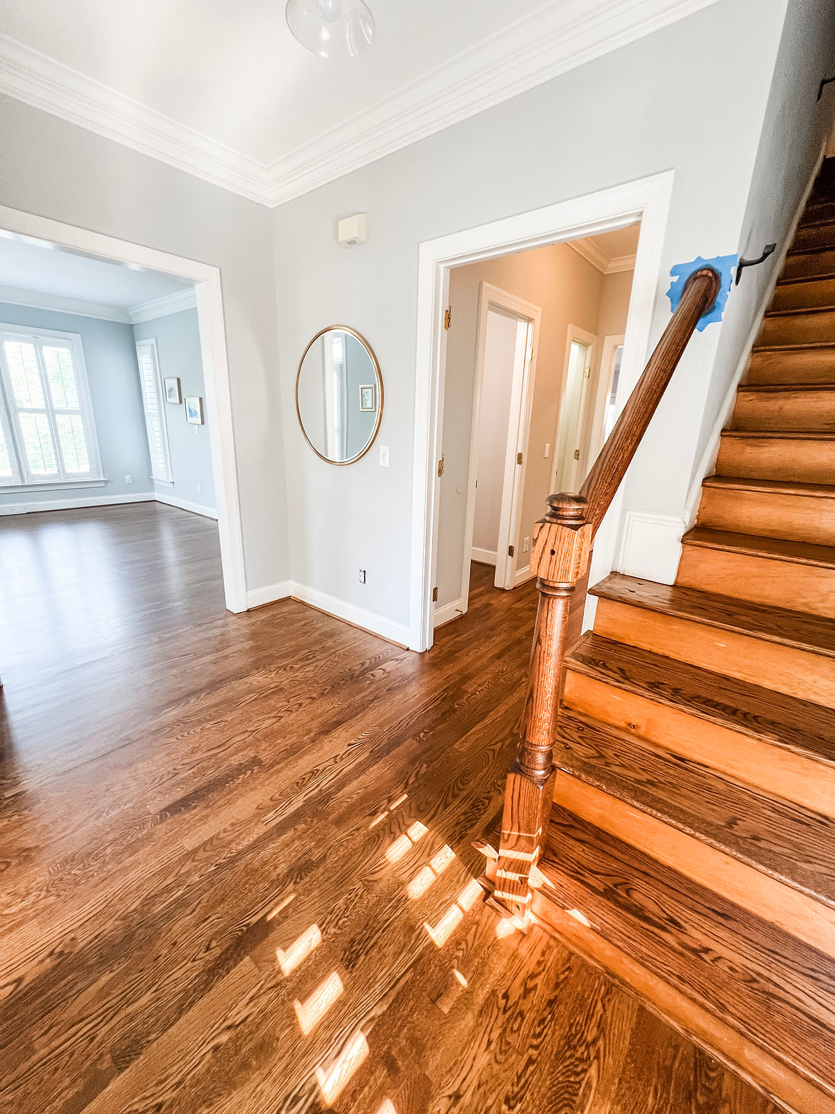 renovated house with hardwood floors, fresh gray walls, and a gold framed mirror