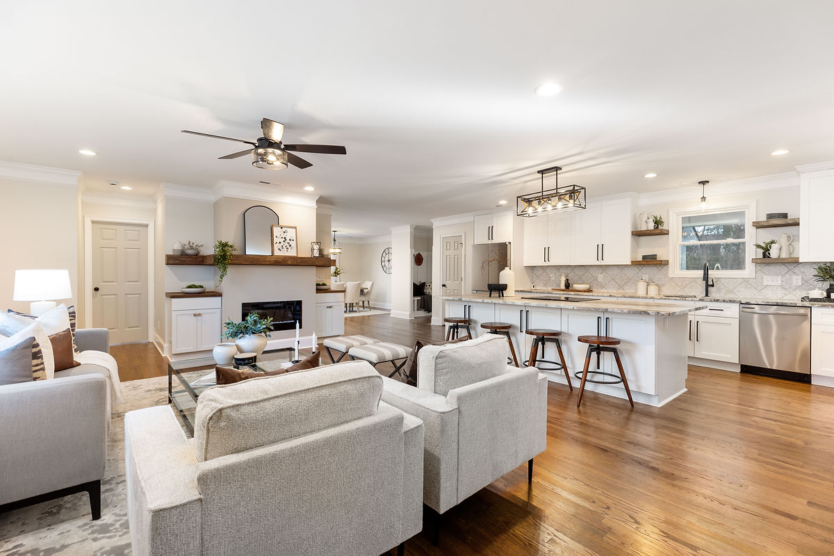 Renovated living room near Huntersville, NC featuring light walls, hardwood floors, and lots of different lighting options.