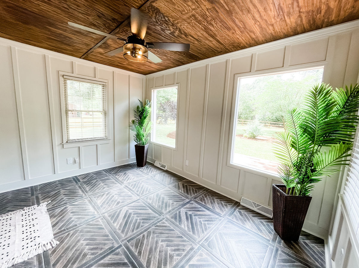 renovated room with wood ceiling, herringbone tile floor, and board and batten walls