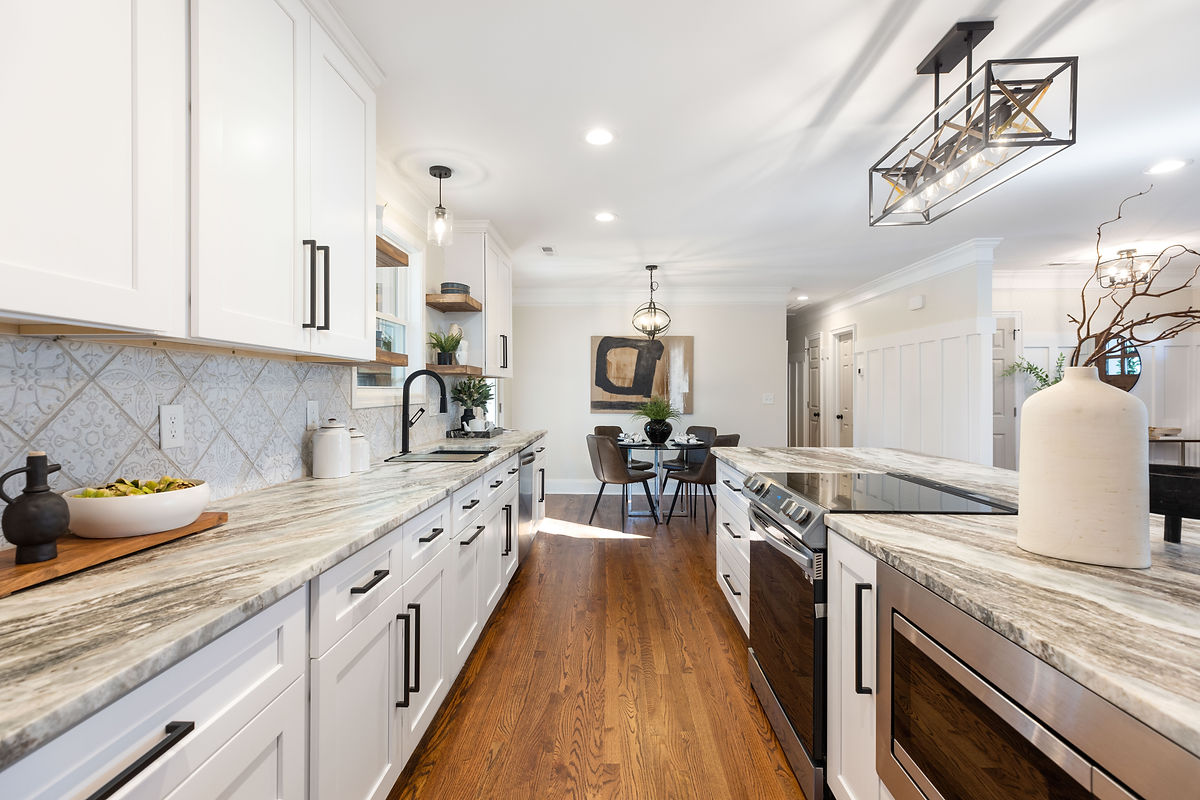 renovated kitchen featuring mixed finishes, white cabinetry, and hardwood floors