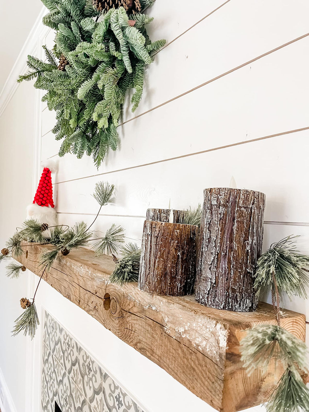 home remodel with festive mantle. A gnome and greenery sit on the rustic beam