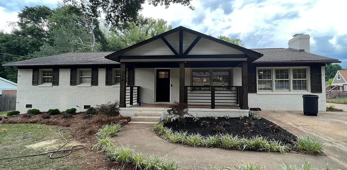 exterior home renovation near Cornelius, NC featuring fresh paint, dark shutters and dark porch railings.