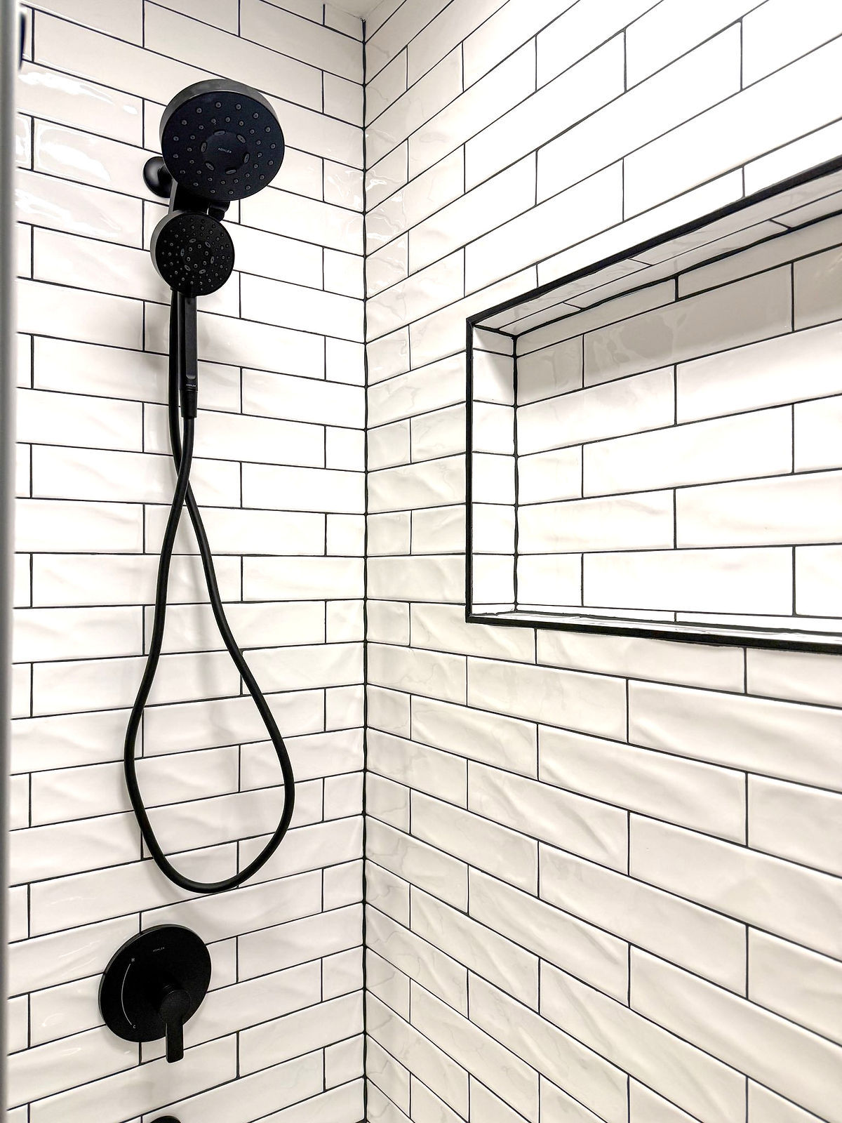 home renovation near cornelius, NC featuring a bathroom renovation showcasing a textured white subway tiled shower with black grout and hardware