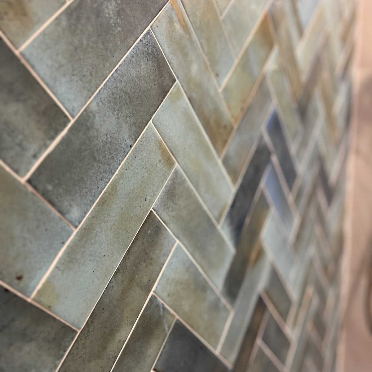 dark gray green tiles arranged in a herringbone pattern
