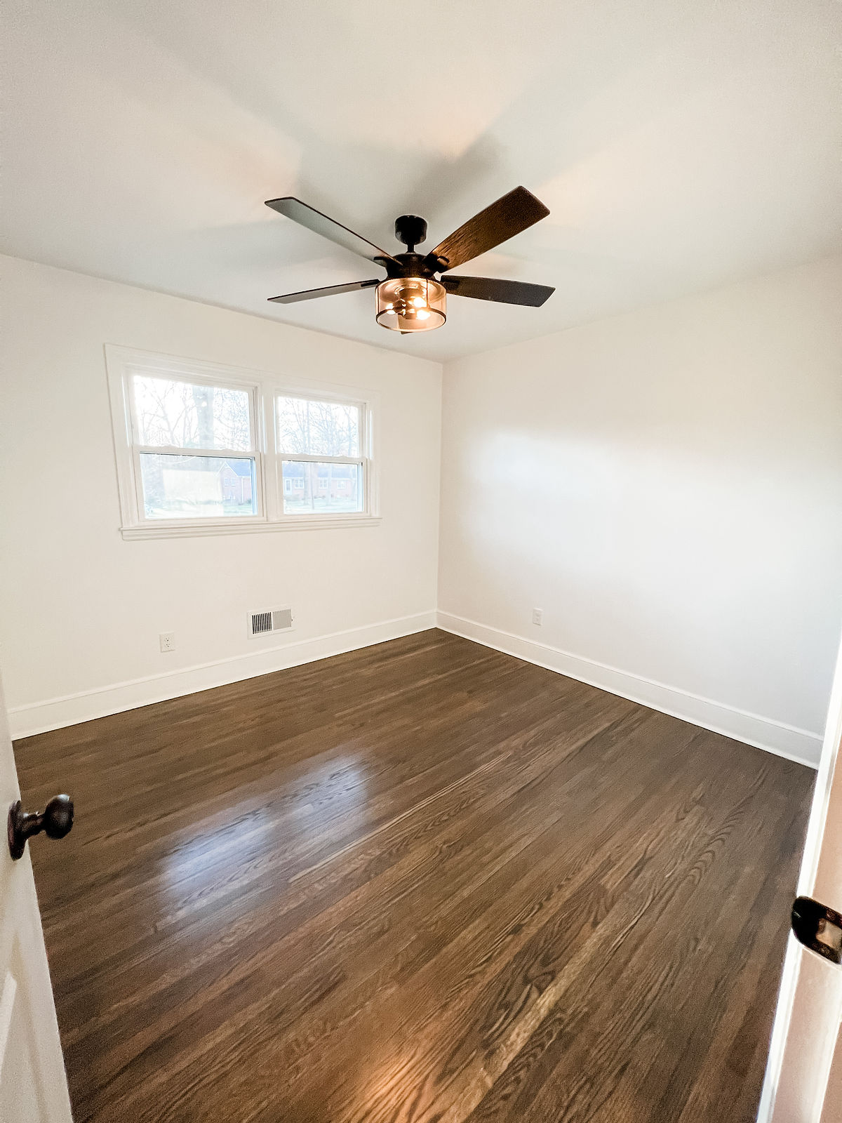a renovated home office with fresh bright paint and hardwood floors