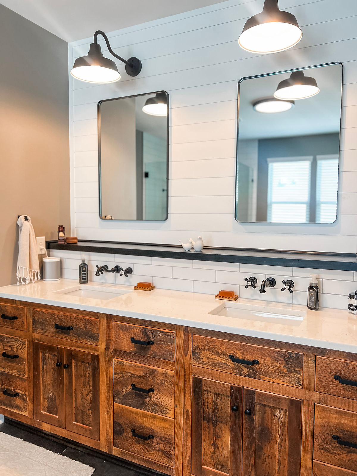 home renovation near Cornelius, NC featuring a renovated bathroom with retro light fixtures, mirrors, and rustic wooden vanity