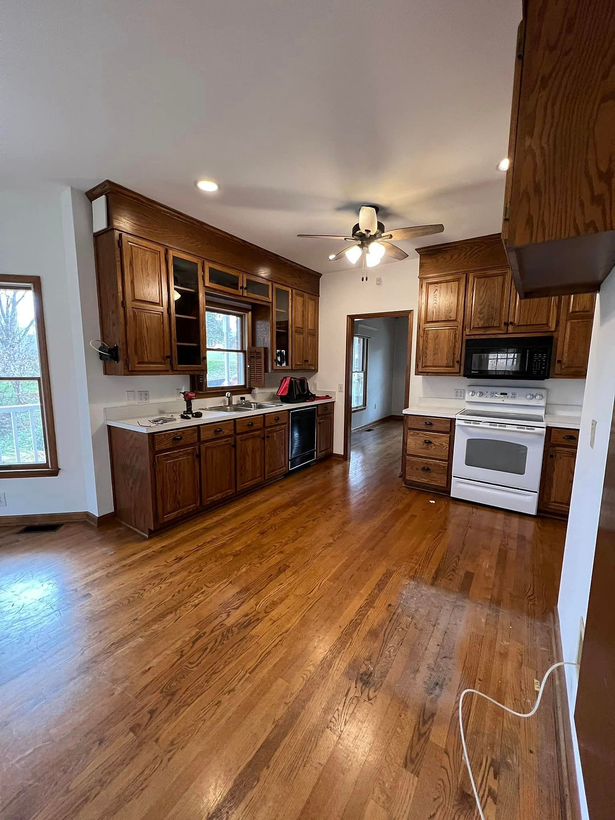 kitchen in need of renovation with dark dated cabinetry, laminate counters, and hardwood floors