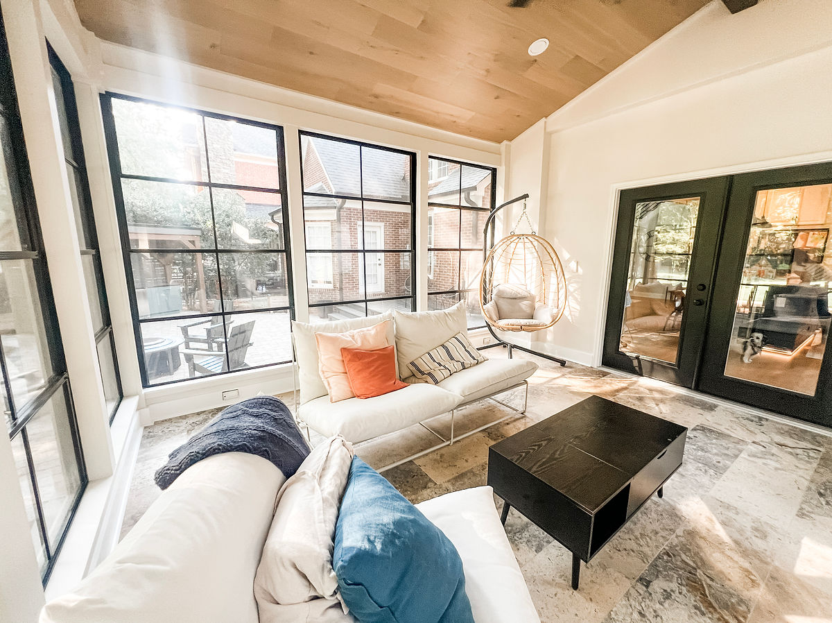 renovated sunroom with large windows, tile flooring, and wood plank ceiling