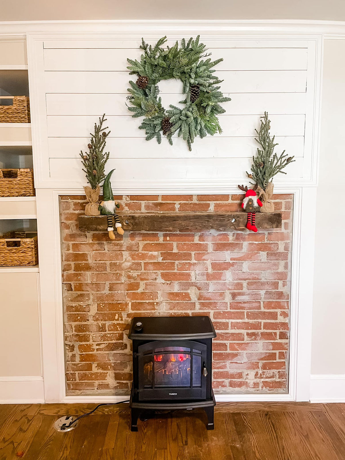 home remodel with festive mantle including gnomes and evergreens