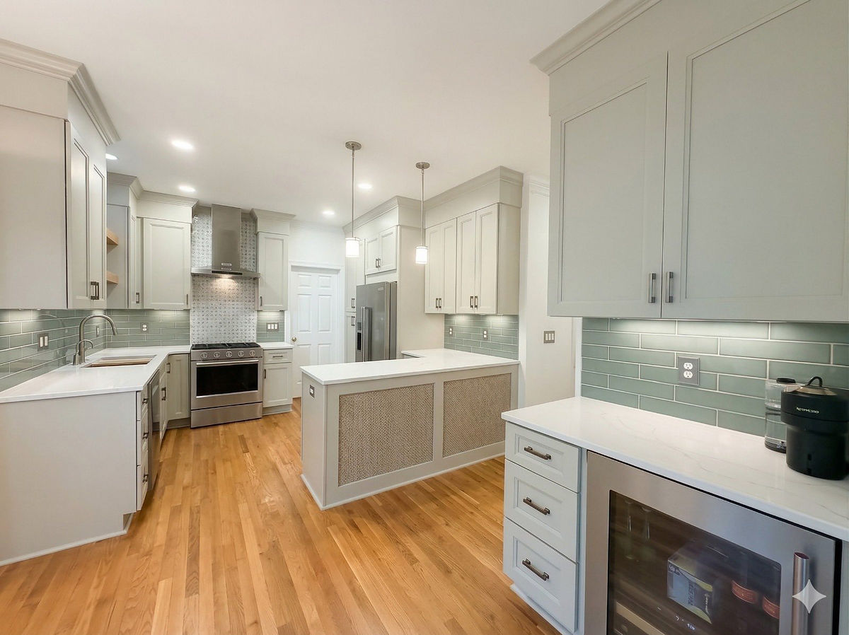 Modern kitchen with white cabinets, green tile backsplash, stainless steel appliances, and wood flooring. Bright and spacious ambiance in this home renovation near Huntersville, NC.