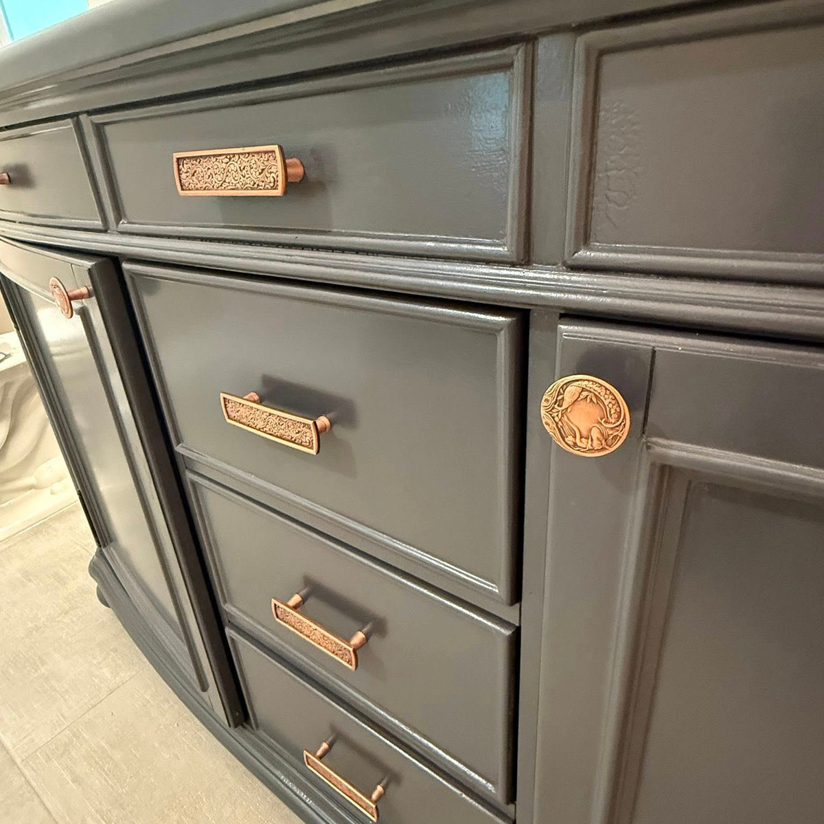 close up on traditional style dark gray vanity with golden knobs and handles