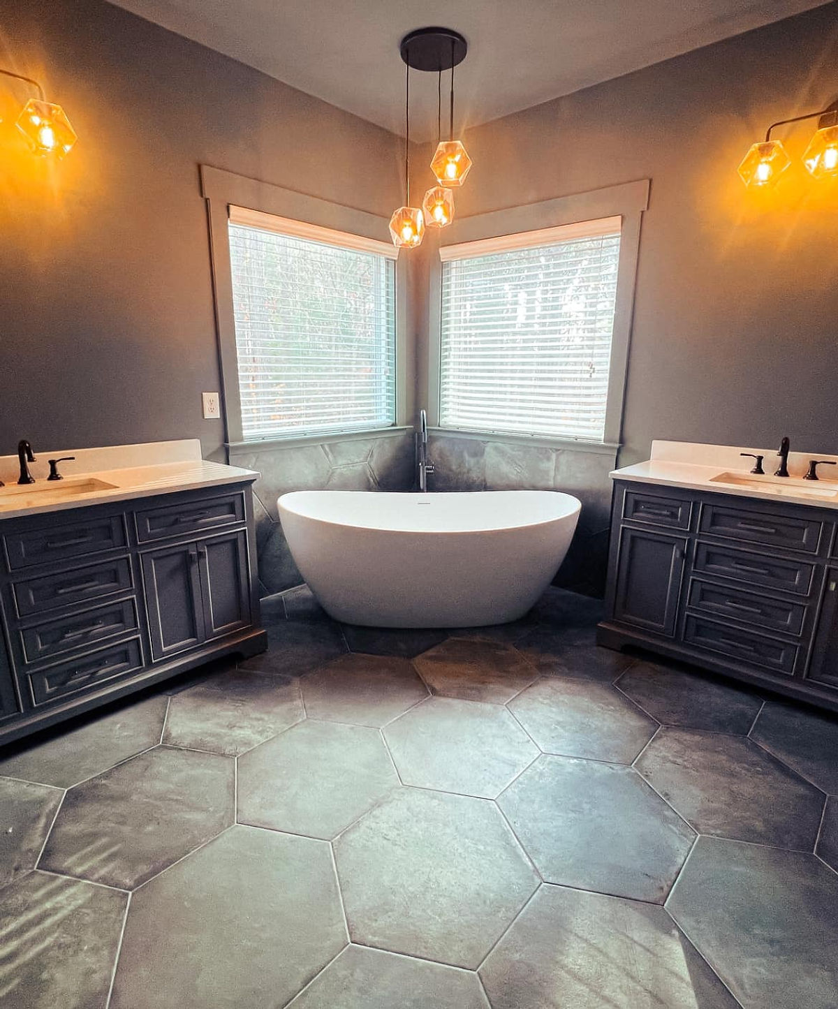 home renovation near Huntersville NC featuring a moody bathroom with soaking tub in the corner between two vanities