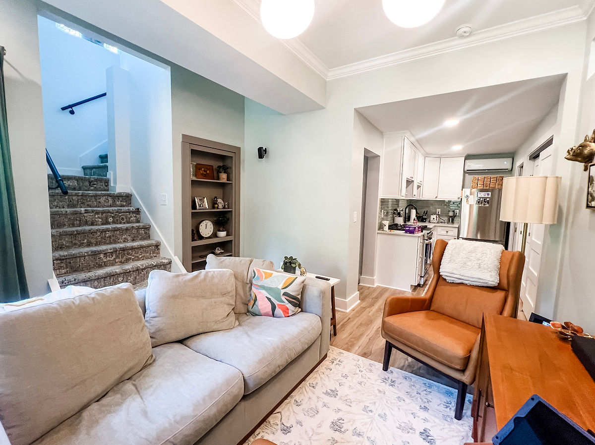home renovation near Huntersville NC featuring a living area with comfy couch and leather chair in the corner, built in bookshelves are featured in the corner
