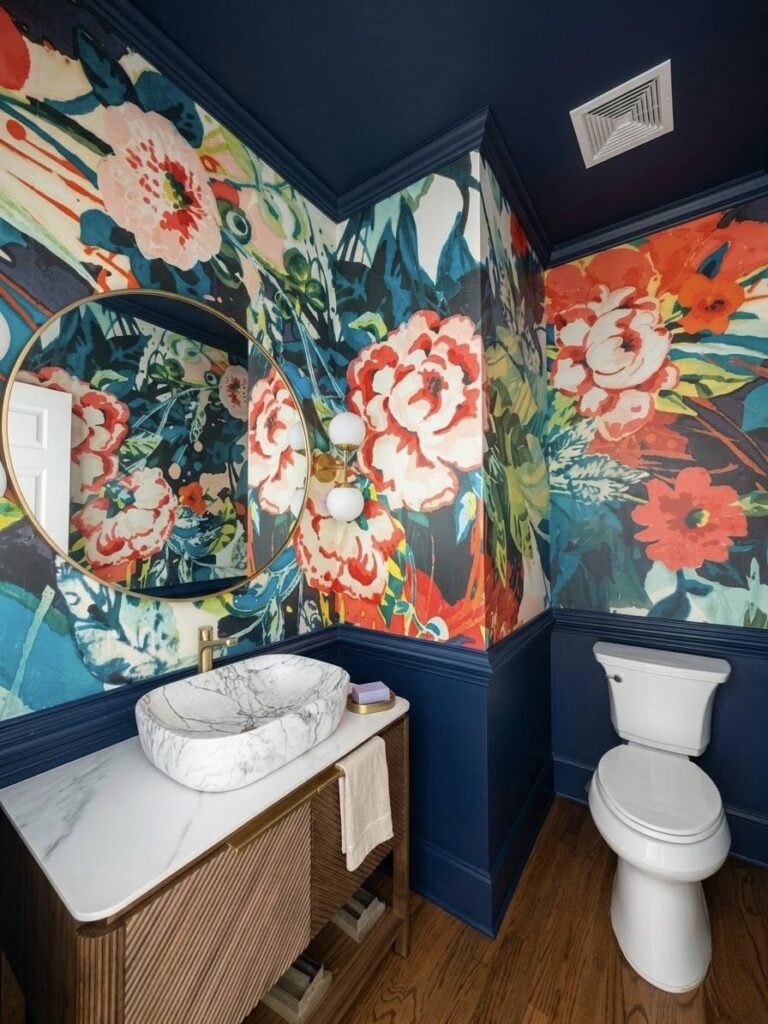 Whole home renovation featuring a bright floral powder room with wall paper and dark blue painted trim.