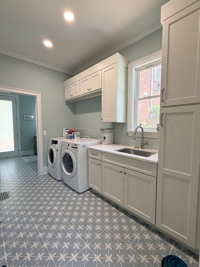 seasonal home design drives this laundry makeover featuring light airy white and light blue color scheme, open floor plan and tons of practical storage cabinets